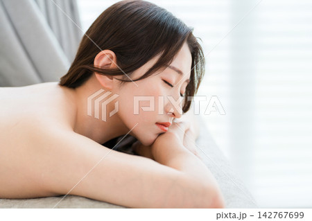 エステサロンで施術を受けながら穏やかにくつろぐ40代50代女性 エステサロンで施術を受けながら穏やかにくつろぐ40代50代女性 142767699