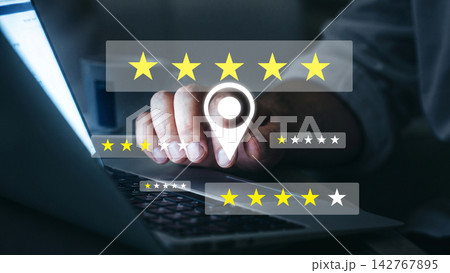 Person rating feedback on a laptop screen with five stars displayed against a dark background Person rating feedback on a laptop screen with five stars displayed against a dark background 142767895