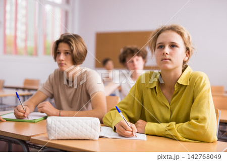 Teenagers doing tasks during lesson in school Teenagers doing tasks during lesson in school 142768049
