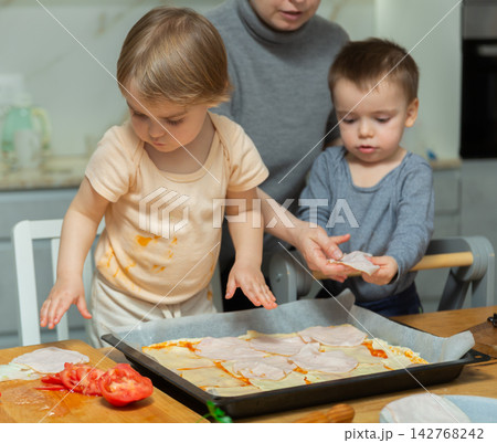 Toddler children help mom cook pizza Toddler children help mom cook pizza 142768242