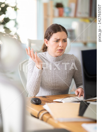 Sad young woman working on computer in office Sad young woman working on computer in office 142768507