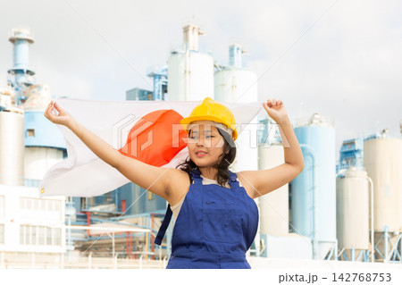 Portrait of smiling girl in construction overalls with the Japan flag on the background of modern factory Portrait of smiling girl in construction overalls with the Japan flag on the background of modern factory 142768753