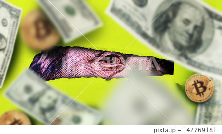 Close-up view of dollar bills and coins near a torn section revealing a dollar bill eye 142769181
