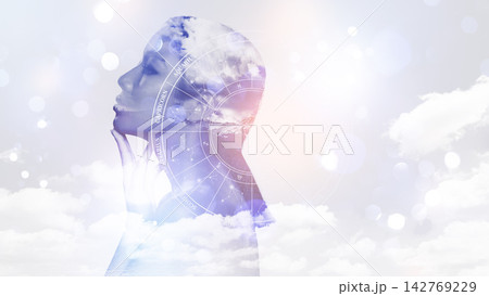 Astrology zodiac signs blend with clouds and a silhouette of a woman in a starry scene Astrology zodiac signs blend with clouds and a silhouette of a woman in a starry scene 142769229