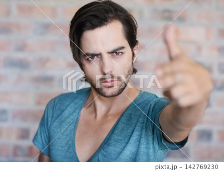 Angry, portrait and man by brick wall with hand gun, confidence or edgy tshirt in Germany. Male person, face or cool model with violence gesture for shooting weapon, pistol fingers or self defence 142769230