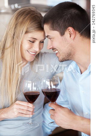 Happy couple, wine and cheers with glass for date, love or romance in kitchen at home. Man and woman with smile enjoying alcohol, drink or beverage together on romantic dinner, meal or lunch at house Happy couple, wine and cheers with glass for date, love or romance in kitchen at home. Man and woman with smile enjoying alcohol, drink or beverage together on romantic dinner, meal or lunch at house 142769345