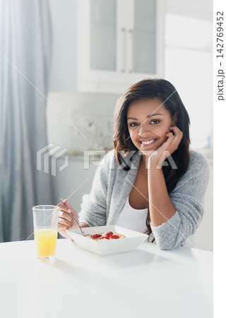 Breakfast, cereal and portrait of woman with orange juice in home with benefits of nutrition in diet. Happy, girl and bowl of granola muesli with fruit and eating for gut health or digestion of food Breakfast, cereal and portrait of woman with orange juice in home with benefits of nutrition in diet. Happy, girl and bowl of granola muesli with fruit and eating for gut health or digestion of food 142769452