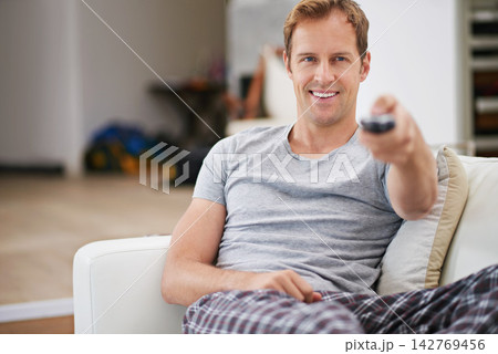 Relax, smile and man watching tv in home living room on sofa for movie, video or streaming show. Comfort, happy person and television remote control in lounge for film, news or media entertainment Relax, smile and man watching tv in home living room on sofa for movie, video or streaming show. Comfort, happy person and television remote control in lounge for film, news or media entertainment 142769456