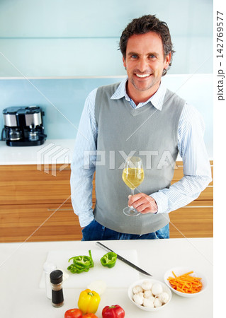 Drinking wine, portrait or happy man cooking vegetables in home for healthy diet, vegan food or nutrition. Alcohol glass, smile or person in kitchen for lunch meal prep, dinner or organic salad above Drinking wine, portrait or happy man cooking vegetables in home for healthy diet, vegan food or nutrition. Alcohol glass, smile or person in kitchen for lunch meal prep, dinner or organic salad above 142769577