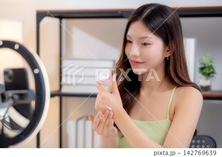 Young asian woman presenting and review cosmetic product with excitement on social media. 142769639