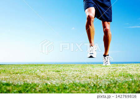 Legs, grass and run for fitness for man, workout and nature with blue sky for cardio. Green, field and exercise for jog for health and wellness for male person, sports and training for soccer match Legs, grass and run for fitness for man, workout and nature with blue sky for cardio. Green, field and exercise for jog for health and wellness for male person, sports and training for soccer match 142769816