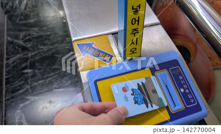 韓国の駅改札で交通カードをタッチする手元 韓国の駅改札で交通カードをタッチする手元 142770004