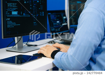IT developer typing code on a keyboard while holding a digital tablet. Modern cybersecurity, software programming, and network analysis IT developer typing code on a keyboard while holding a digital tablet. Modern cybersecurity, software programming, and network analysis 142770484