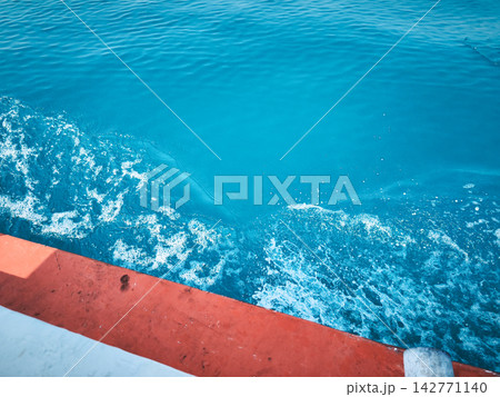 Clear sea water spray beside white and orange boat 142771140