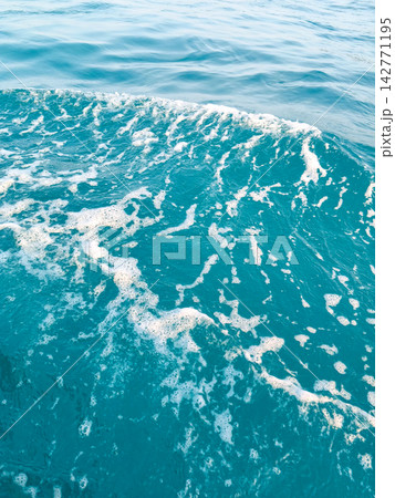 Ripples and foam texture on clear blue sea water. Ripples and foam texture on clear blue sea water. 142771195
