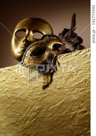 Golden carnival masks on a gold background. Golden carnival masks on a gold background. 142773492