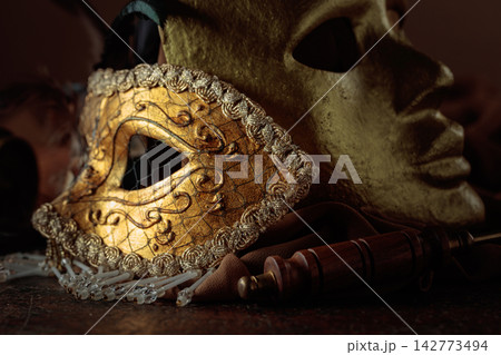 Golden carnival masks on a brown background. Golden carnival masks on a brown background. 142773494