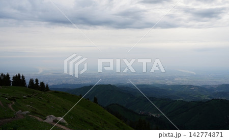 Scenic mountain view overlooking valley and cityscape under cloudy sky Scenic mountain view overlooking valley and cityscape under cloudy sky 142774871