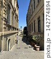 Passage in the old town between houses. An alleyway or a narrow passage between buildings, sunny day, no people. 142774894