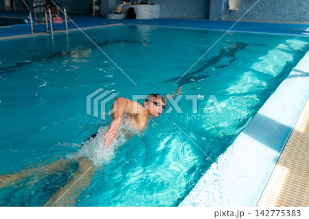 Athlete practicing freestyle stroke in blue water 142775383