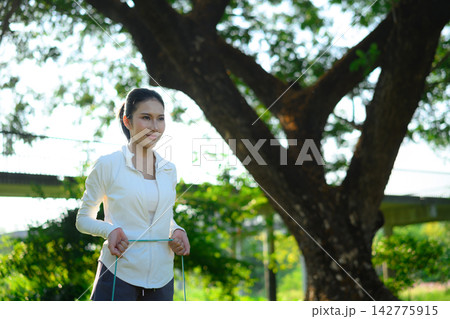 Sports woman exercising with resistance band at park Sports woman exercising with resistance band at park 142775915