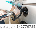 Person refueling car at gas station wearing gloves for hygiene 142776785
