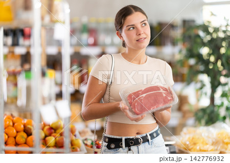 Young woman choosing entrecote in grocery store Young woman choosing entrecote in grocery store 142776932