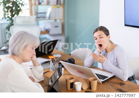 Tired women sleeps next to computer at work. 142777097