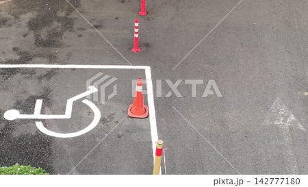 Handicap accessible parking spot with orange traffic cones on asphalt pavement Handicap accessible parking spot with orange traffic cones on asphalt pavement 142777180