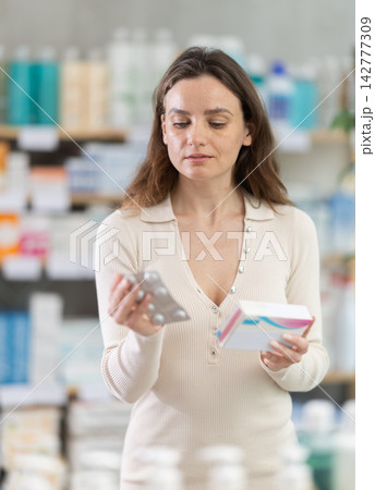Woman choose pills in pharmacy 142777309