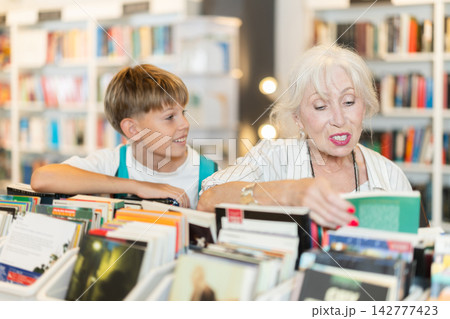 In bookstore grandson with grandmother choose book In bookstore grandson with grandmother choose book 142777423