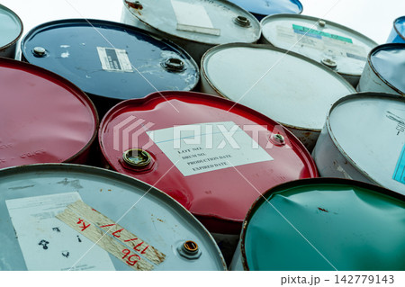Old chemical barrels stack. Red, green, and blue chemical drum. Steel tank of flammable liquid. Hazard chemical barrel. Industrial waste. Empty chemical barrels at the factory warehouse. Hazard waste. Old chemical barrels stack. Red, green, and blue chemical drum. Steel tank of flammable liquid. Hazard chemical barrel. Industrial waste. Empty chemical barrels at the factory warehouse. Hazard waste. 142779143