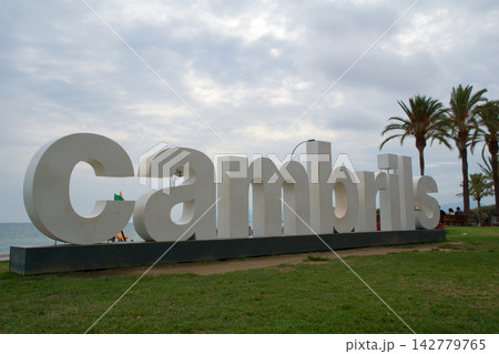 Cambrils, Spain, August 27 2017: Large Cambrils city sign at the promenade with palm trees 142779765