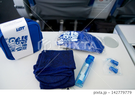 Warsaw, Poland, May 10 2018: Premium economy amenity kit contents displayed on tray table Warsaw, Poland, May 10 2018: Premium economy amenity kit contents displayed on tray table 142779779