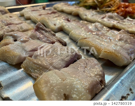 鉄板の上に並べられた厚切りサムギョプサル 鉄板の上に並べられた厚切りサムギョプサル 142780319