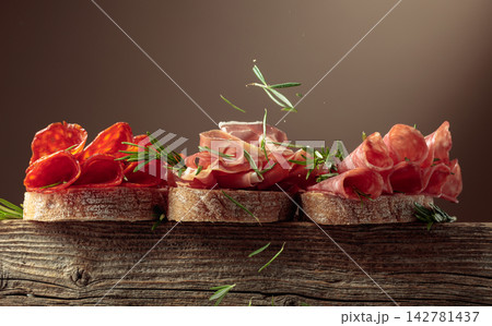 Sandwich with thin slices of Italian dry cured prosciutto, salami, and chorizo sausages. Sandwich with thin slices of Italian dry cured prosciutto, salami, and chorizo sausages. 142781437