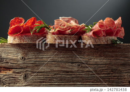 Sandwich with thin slices of Italian dry cured prosciutto, salami, and chorizo sausages. Sandwich with thin slices of Italian dry cured prosciutto, salami, and chorizo sausages. 142781438