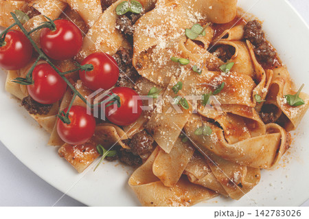pappardelle pasta with bolognese sauce, topped with parmesan cheese and cherry branch, homemade, no people, 142783026