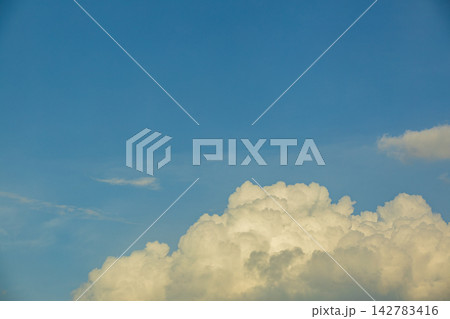 Vast blue sky filled with fluffy white cumulus clouds on a sunny day 142783416