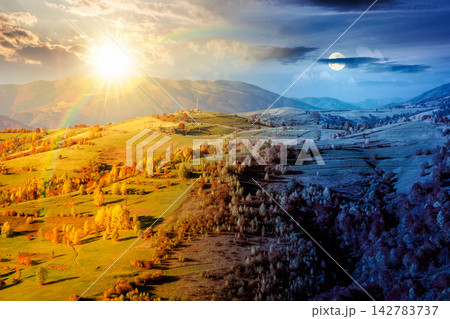 countryside landscape in autumn. day meet night. sun and moon over rural scenery in Carpathian mountains. colorful deciduous forest by the rural fields on a hillside under epic sky countryside landscape in autumn. day meet night. sun and moon over rural scenery in Carpathian mountains. colorful deciduous forest by the rural fields on a hillside under epic sky 142783737