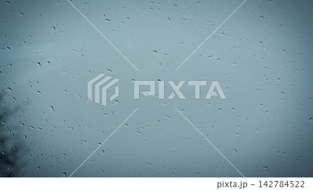 Raindrops streak across a misty window pane Raindrops streak across a misty window pane 142784522