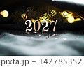 New Year's holiday background with bokeh with the number of the year 2027. 142785352