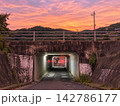 夕焼けに染まる山間のアンダーパスと道路 142786177