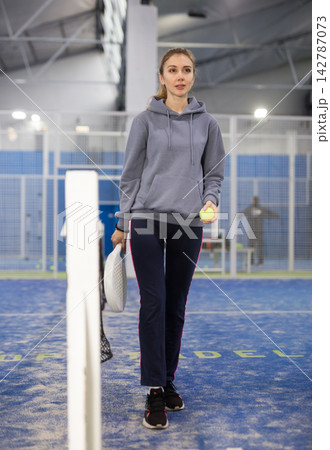 Woman padel player at net in court Woman padel player at net in court 142787073