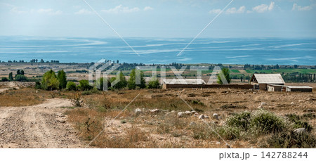 Distant view of Issyk Kul lake and rural settlement Kyrgyzstan Distant view of Issyk Kul lake and rural settlement Kyrgyzstan 142788244