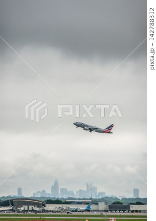 Commercial aircraft taking off with the Charlotte skyline visible on the horizon under a heavy overcast sky in North Carolina Commercial aircraft taking off with the Charlotte skyline visible on the horizon under a heavy overcast sky in North Carolina 142788312