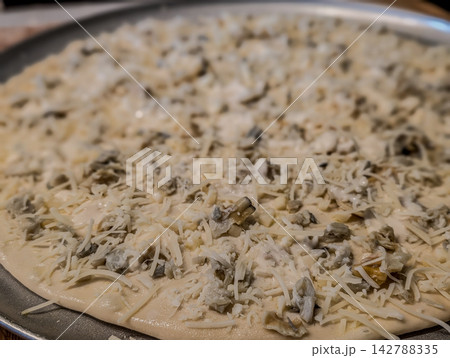 Uncooked white clam pie pizza on metal pan Uncooked white clam pie pizza on metal pan 142788335
