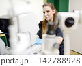 Portrait of a young ophthalmologist at their workplace. Specialist consultation, vision testing, early diagnosis, and treatment of eye diseases. 142788928