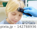 A pediatrician measures a young patient's temperature in the doctor's office. The electronic thermometer shows a temperature of 36.6 degrees. 142788936