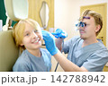 A preteen boy is seen by otolaryngologist. The ENT specialist examines the patient's inner ear using an otoscope. Treatment of an inflammatory ear condition. 142788942